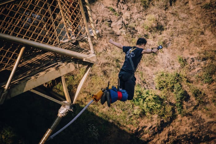 Man jumps off the Victoria Falls bungee jump platform with a GoPro in his hand