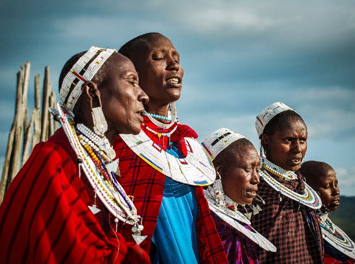 Maasai women singing, wearing colourful traditional jewellery