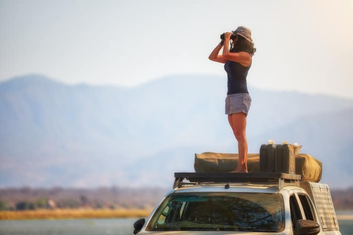 Woman observing animals from the top of a 4x4, Lower Zambezi